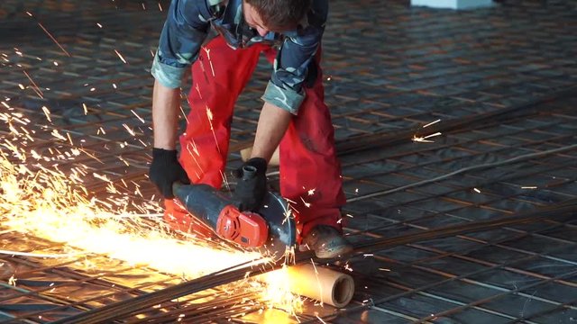 Man works circular saw in slow motion. Flies of spark from hot metal. The man's hard work. Man Chlef and smooth surface. Man worked over the steel. close-up of hand and electric saws metal. Close-up