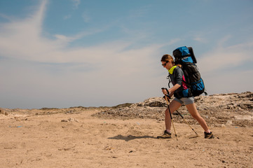 Girl walking in the desert with hiking backpack