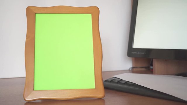 Take a photo frame from the table and put it back. Emotion feelings state of mind. Green screen in photo frame.