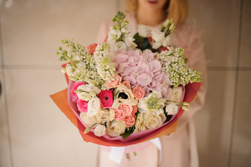 Woman holding a bouquet of tender pink and white flowers
