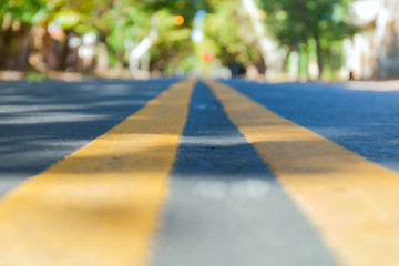 Obraz premium Abstract blurred background road leading through an autumn city surrounded by trees