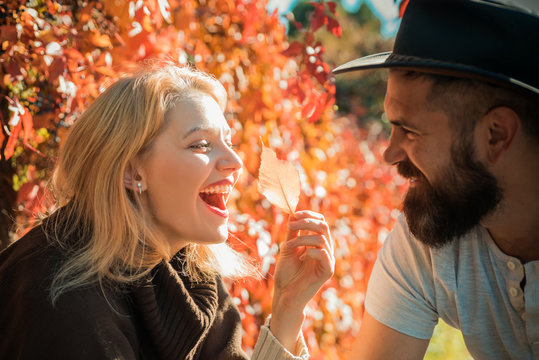 Autumn couple. Happy smiling attractive young couple on date sitting in street cafe in autumn, sharing drink, looking at each other with love, flirting, having fun together.