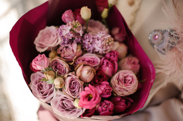 Close up girl in the coat holding a bouquet of purple violet flowers