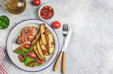 Grilled steaks, French fries and vegetables on light gray background. Top vew