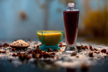 Face mask for skin whitening on wooden surface consisting of besan or gram flour and some rose water. With some dried rose petals and gram flour spread on the surface.