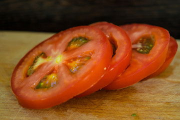 Sliced ​​tomatoes on the rings close-up on a cutting board