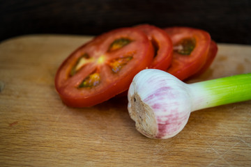 Sliced ​​Tomatoes and Fresh Garlic on Cutting Board