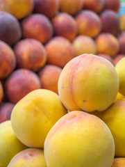 several types of  peaches and fruit on the shelf of a fruit store