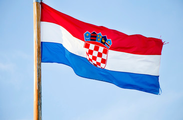 Croatian national flag fluttering against the blue sky