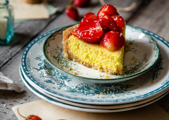 Slice of homemade delicious strawberry tart or pie with sweet glazed berries on top