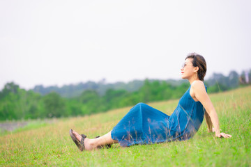 young happy asian pregnant woman relaxing and enjoying life in nature