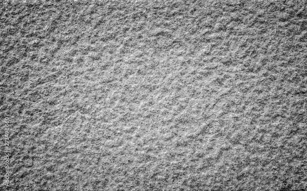 Poster close-up of a bumpy granite stone wall in black and white with vignetting. high resolution full fram