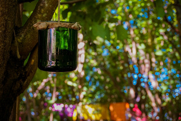 Handmade dream catcher hanging in a green forest. Festival decoration.