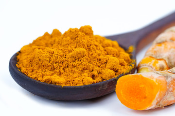 Turmeric roots and powder herb on wooden background.