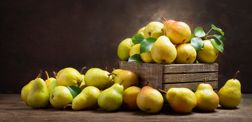 fresh pears with leaves in a wooden box