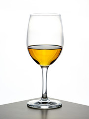 transparent wine glass with cognac being poured in