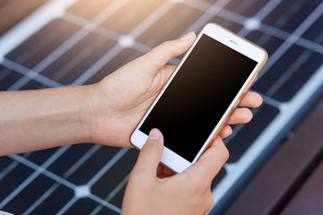 Outdoor photo of faceless person harging mobile phone via USB. Public charging on bench with solar panel on city street. Alternative electricity source, ecology, renewable energy, modern technology.