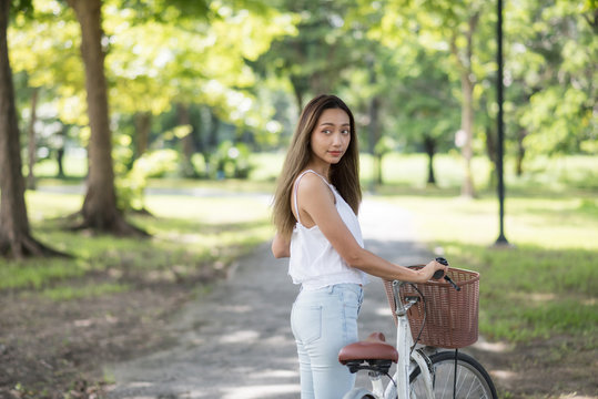 Attractive girl with bicycle in park