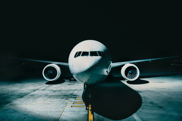 Airliner plane parked at the terminal view from the front cockpit fuselage, on runway at night
