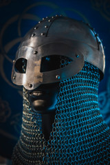 Soldier Viking helmet with chain mail of iron on red shield of wood and golden triskel