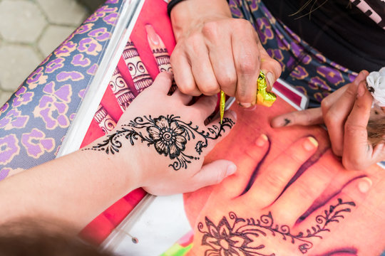 Henna tattoo. Flower drawing in process.