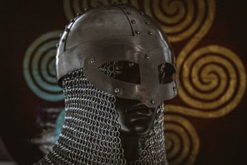 Traditional Vikings, viking helmet with chain mail on a red shield with golden shapes of sun, weapons for war