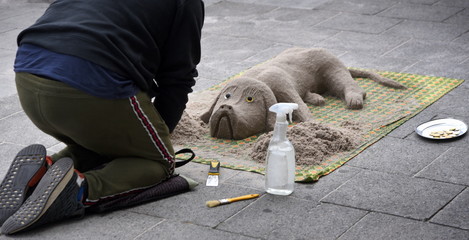 Sandhund eines Straßenkünstlers in einer Fußgängerzone