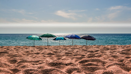 fünf Sonnenschirme am Strand