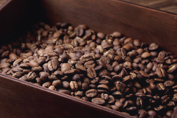 natural coffee beans in a wooden box on a natural wooden background  soft backlight