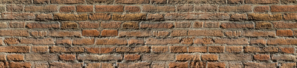 Vintage brick wall texture in contrast lighting for design. Panoramic background for text and image.
