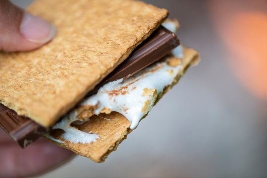 A gooey s'more made by a campfire