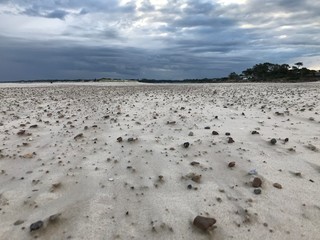 Storm clouds in Pinamar beach and sand with stones