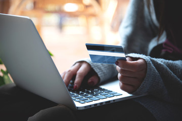 Frau mit Kreditkarte und Laptop zuhause