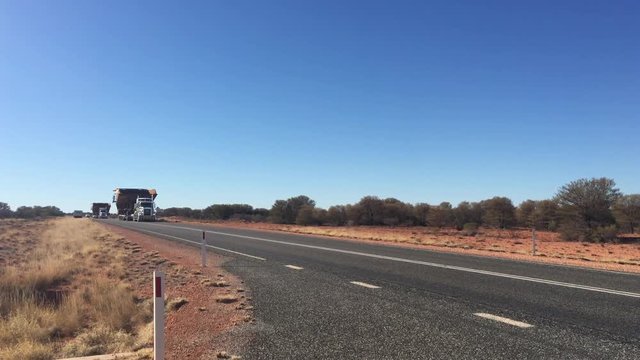 Oversize vehicle convoy on Stuart highway in the red center of Australia outback.Load shifting in the responsibility of the shipper, motor carrier, driver and the receiver