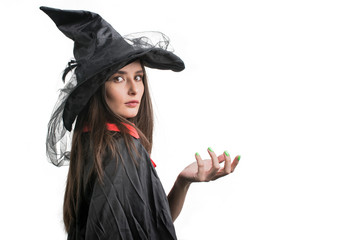 Happy gothic young woman in witch halloween costume with hat standing over white background