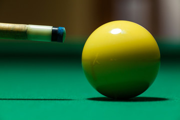 Close up view of pool cue near to the white ball