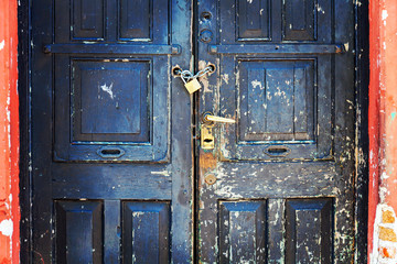 The old door is padlocked. Numerous locks installed on one single door.