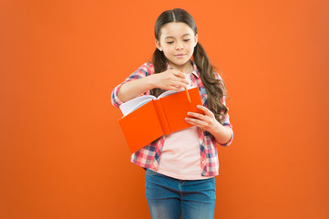 Entering a different world. Literature education. Little girl with book of english literature. Small child reading childrens literature on orange background. Literature lesson at school