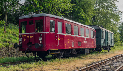 Fototapeta na wymiar Red old historical diesel train with cargo green car in Ceska Kamenice town