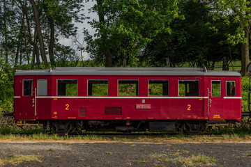 Fototapeta na wymiar Red old historical diesel train with cargo green car in Ceska Kamenice town