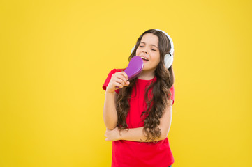 Keep a song in your heart. Adorable song singer. Cute small child doing vocal on song on yellow background. Little girl singing song playing in headphones