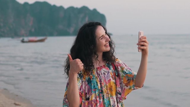 girl makes a video call by the ocean