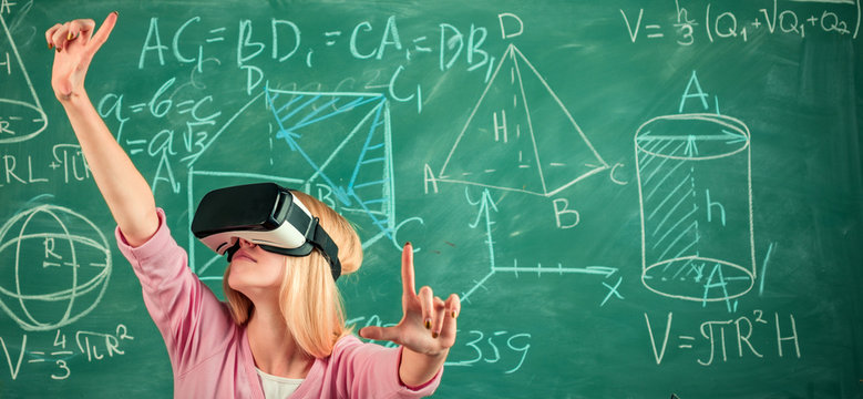 Portrait Of Blonde Woman Student Absorbed By Virtual Reality Headset On Green Chalkboard Background. Education In High School University College.