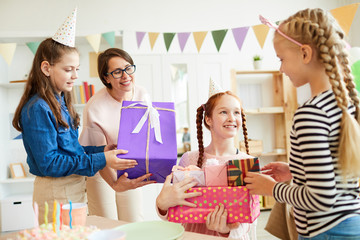 Portrait of happy red haired  girl receiving gifts from friends during Birthday party, copy space