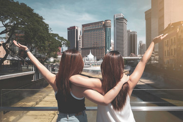 Rear of two young women enjoy holiday in Kuala Lumpur, Malaysia