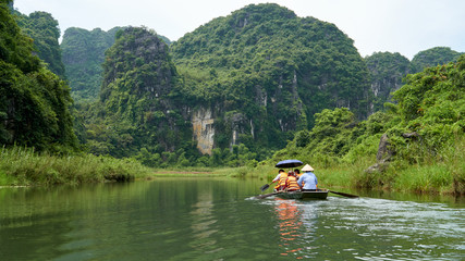 Boat with tourists, beautiful landscape with karst mountains and river in Trang An, Ninh Binh, Tam Coc, Vietnam. 