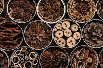 Insect house -hotel, made of used coffee cans and various wooden and plants parts