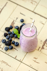 Blueberry smoothie in bottle on wooden background. Top view, vertical orientation. Concept of clean eating
