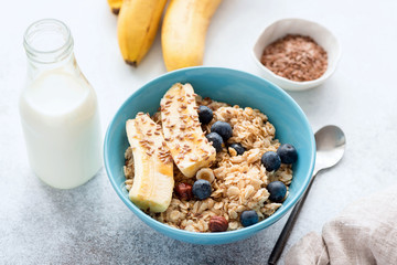 Oatmeal porridge with banana, blueberry, nuts and bottle of milk. Healthy breakfast food