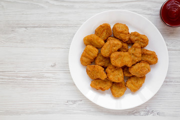 Chicken nuggets and ketchup on a white wooden background. Overhead, from above, flat lay. Copy space.